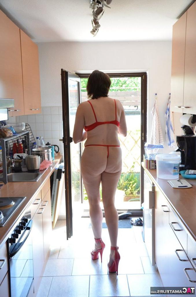 20P Mujer de piernas largas hace sus tareas domésticas en sujetador y tanga con tacones a juego