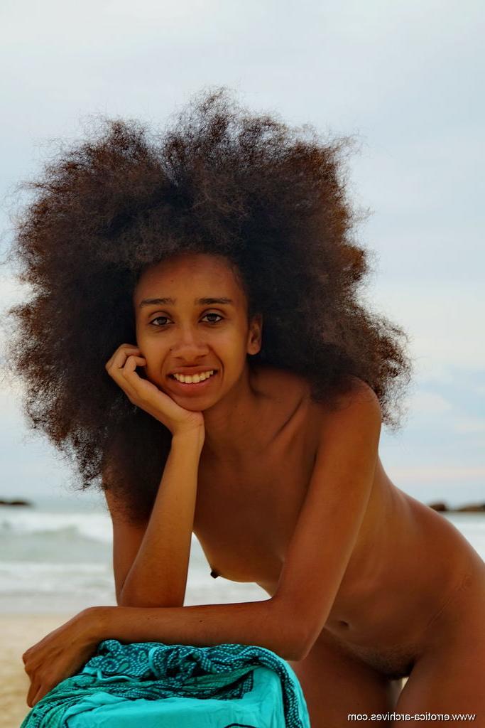 16P La joven de ébano Isadora luce un gran cabello mientras posa desnuda en la playa
