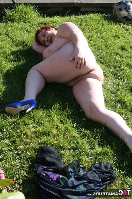 20P Altes Amateurmodell mit kurzen roten Haaren nackt auf dem Rasen im Hinterhof