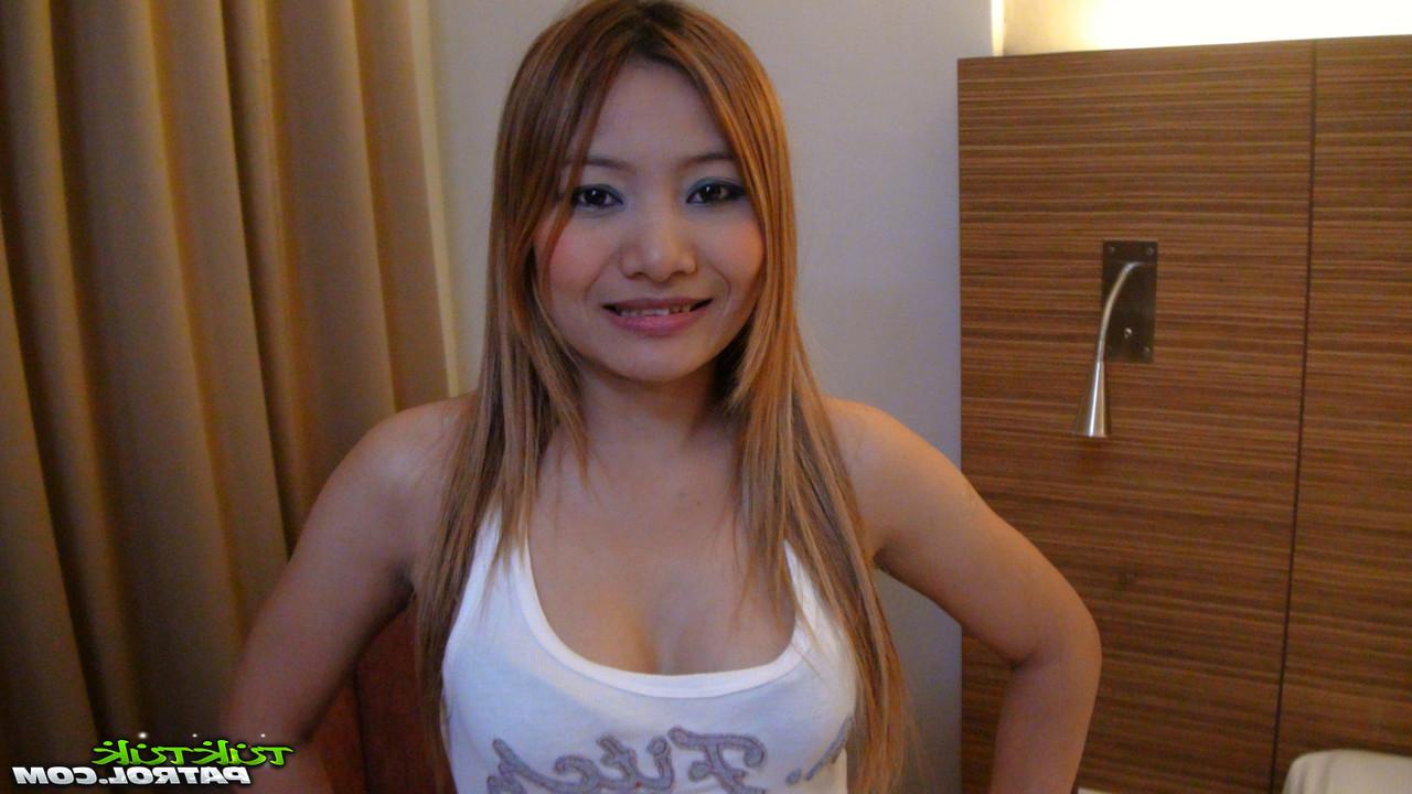 15P Das thailändische Barmädchen Ning trägt nach dem Sex auf einem Bett mit einem Farang eine Perlenkette