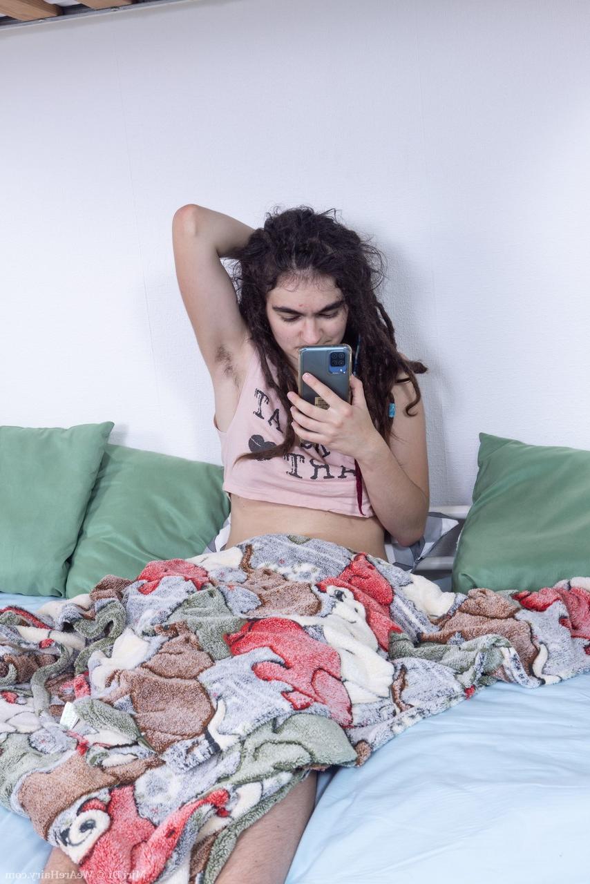 20P Horny American hippie Miri D toying her extremely hairy pussy on the bed
