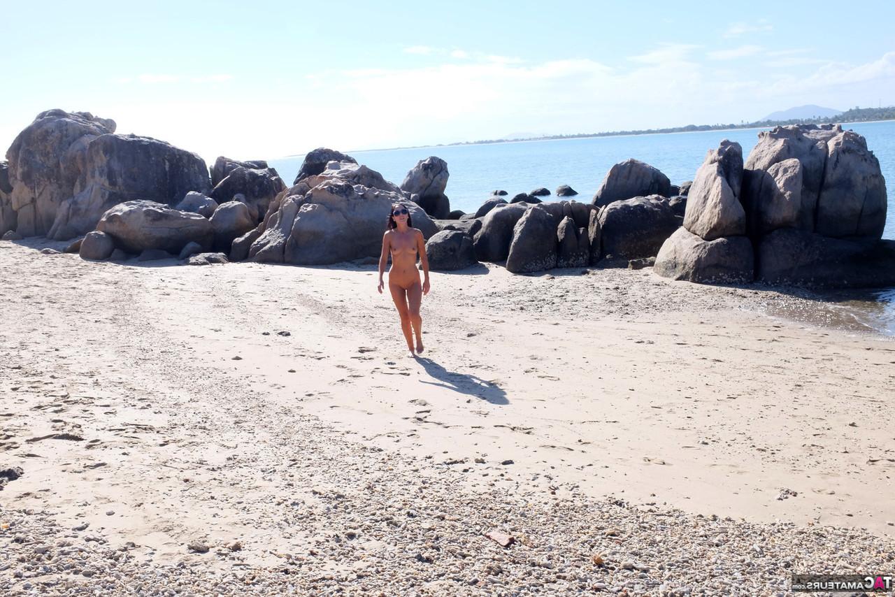 16P Die brünette MILF Roxeanne zieht sich am Strand mit Sonnenbrille aus