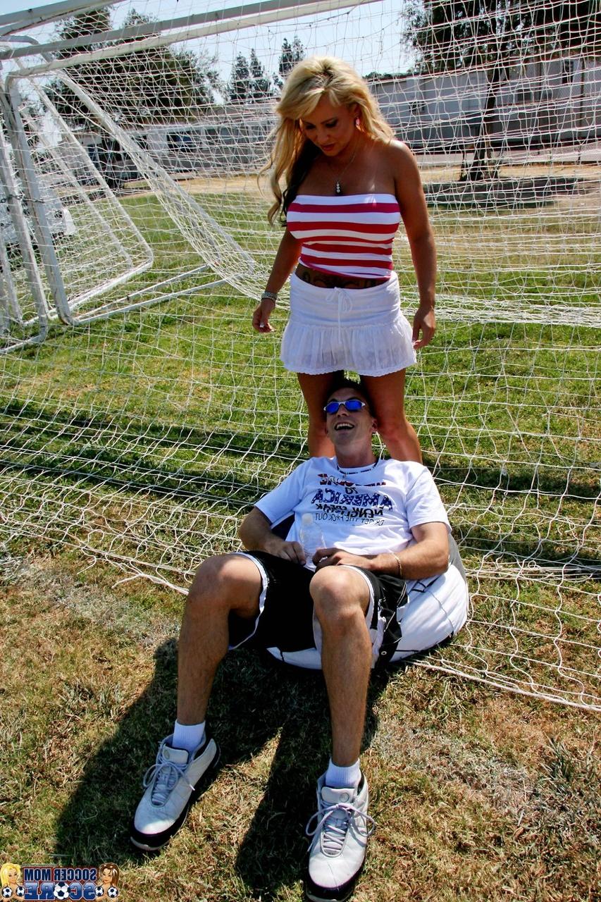 17P Milan, maman blonde du football, donne à un jeune joueur un aperçu illicite de sa jupe.