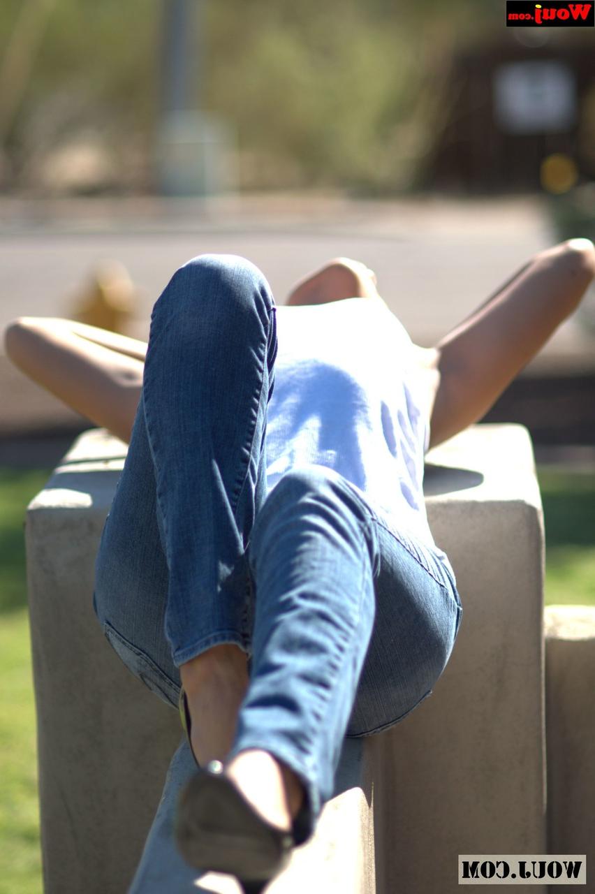 15P Gata amadora bronzeada posando com camisa branca e jeans azul em público