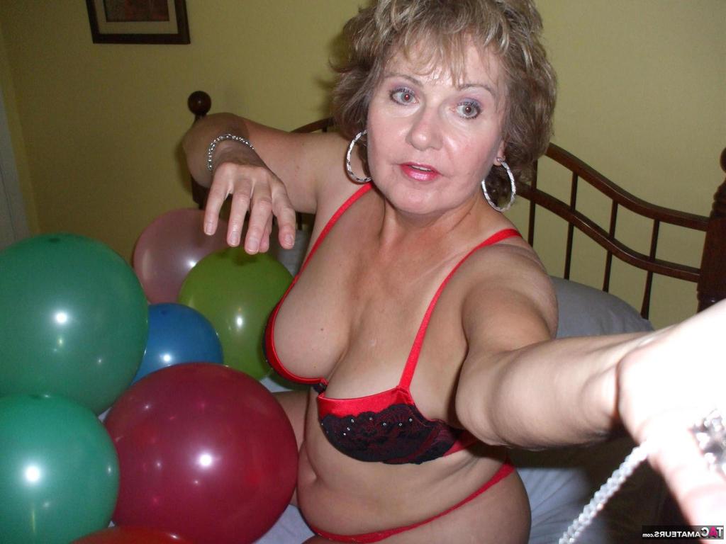 20P Older lady Busty Bliss plays with balloons before uncupping her natural tits