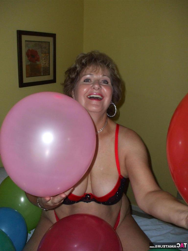 20P Older lady Busty Bliss plays with balloons before uncupping her natural tits