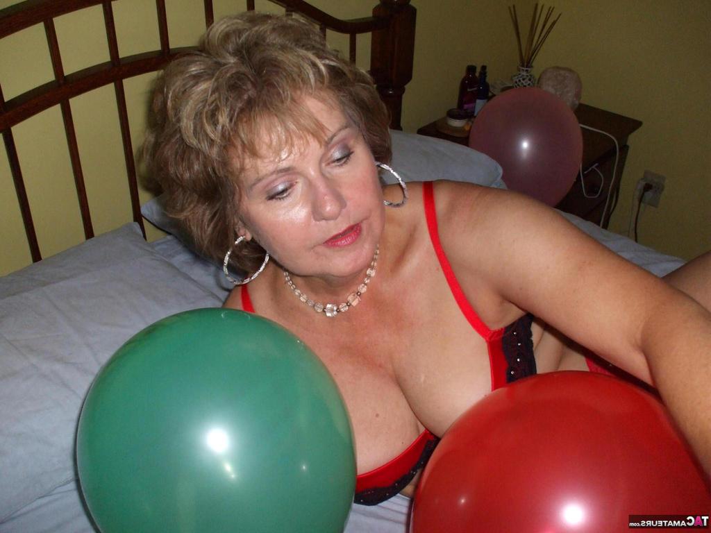 20P Older lady Busty Bliss plays with balloons before uncupping her natural tits