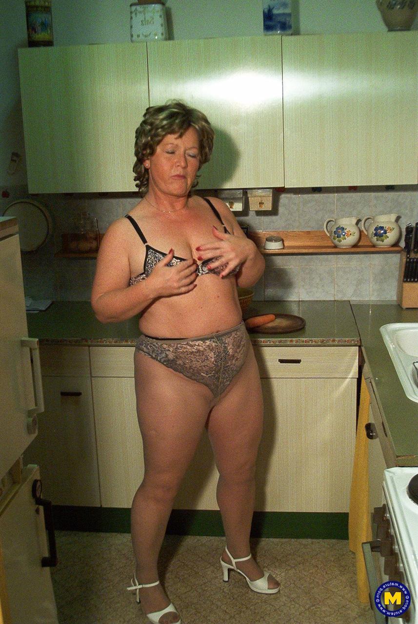 20P La petite mamie Rita enlève sa robe et ses bas de nylon et se masturbe dans la cuisine.