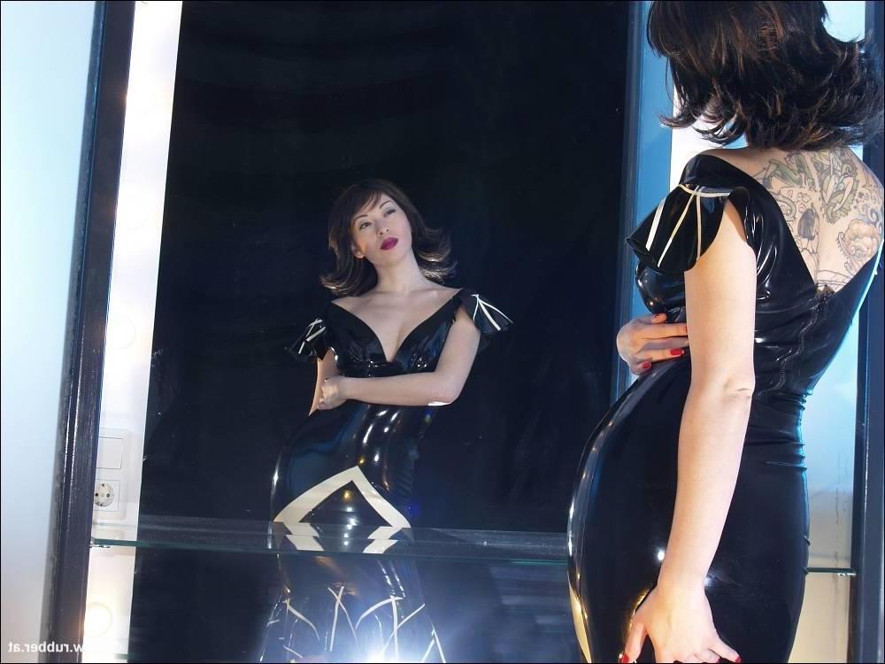 16P Bonita morena luce lápiz labial mientras fuma en ropa de látex