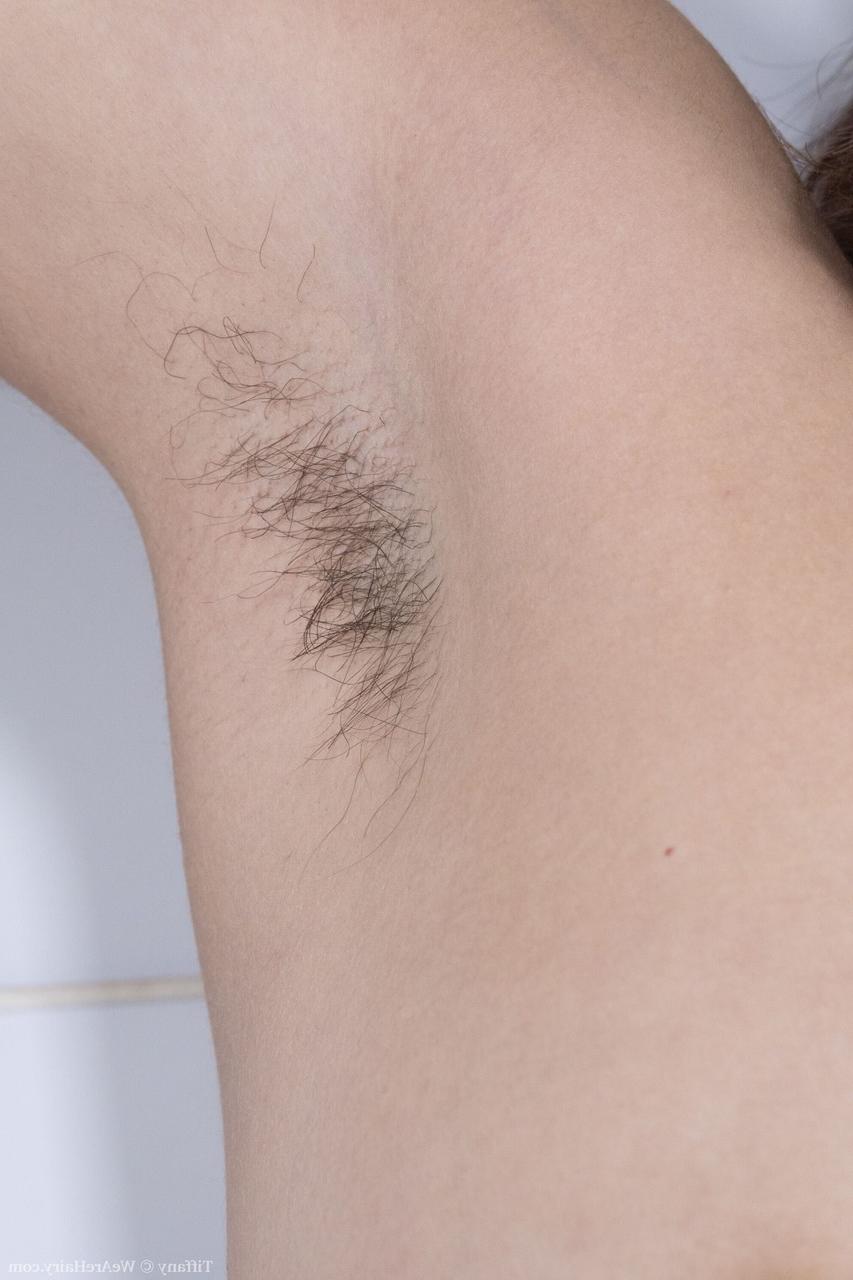 20P Tiffany, une jeune femme bien roulée, écarte sa chatte poilue de près lors d'un strip-tease sexy.