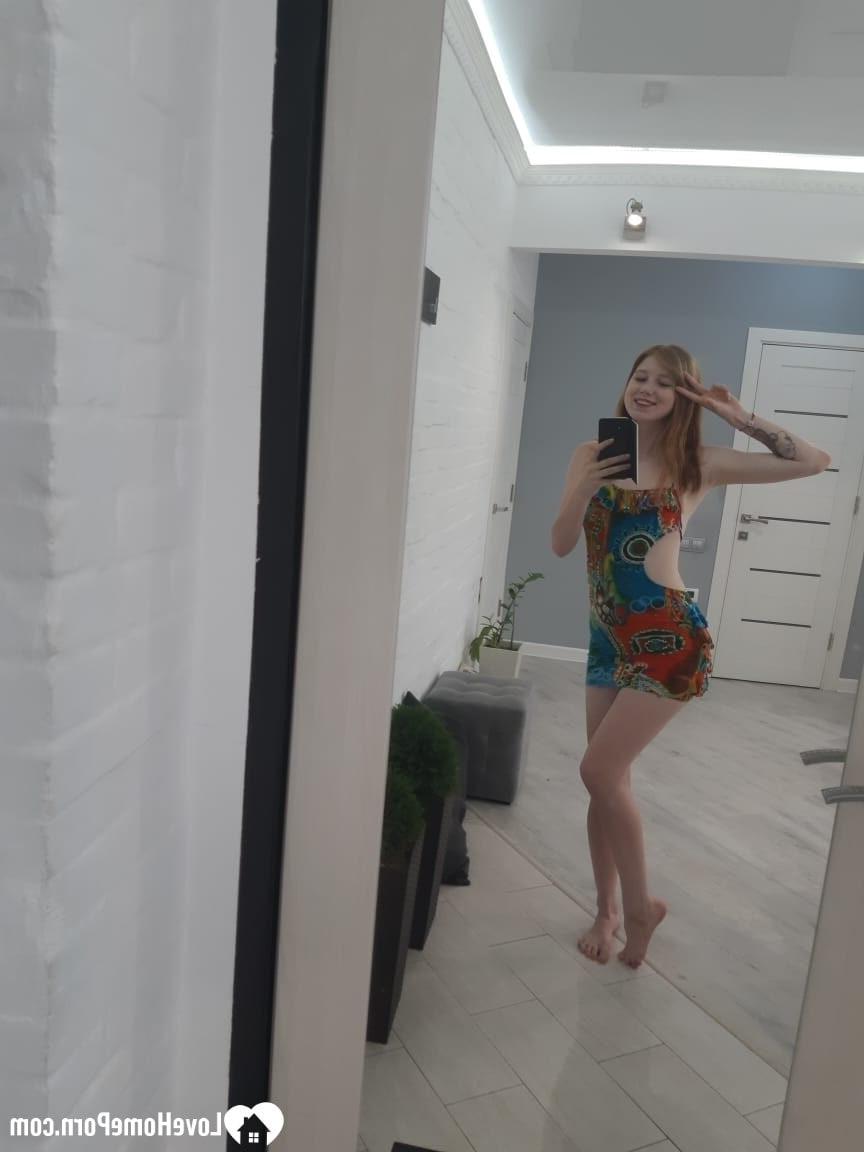 20P Chica pelirroja caliente se quita su vestido colorido y posa desnuda en el espejo