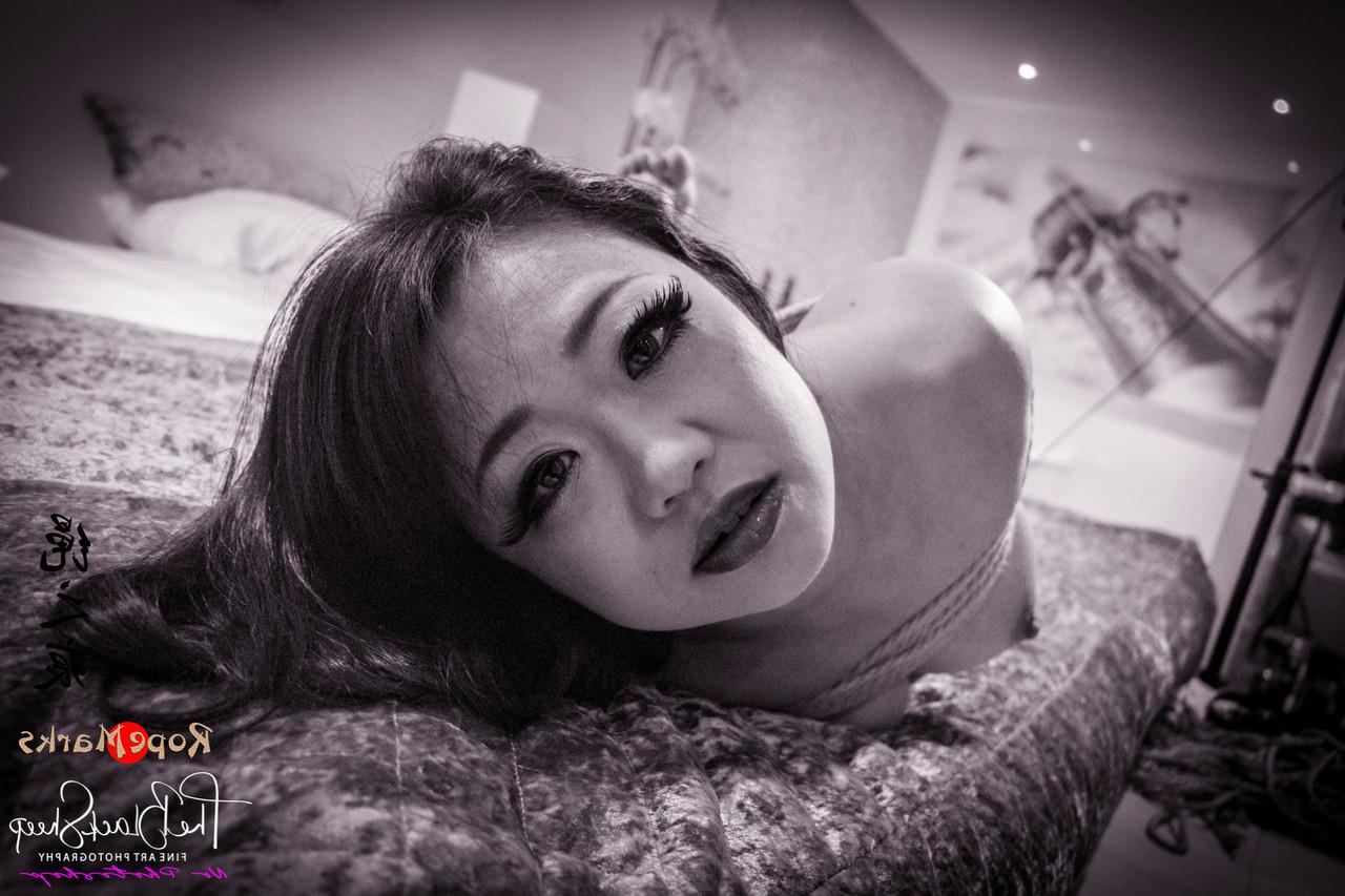 16P Asian chick is tied up with ropes on a bed before being blindfolded