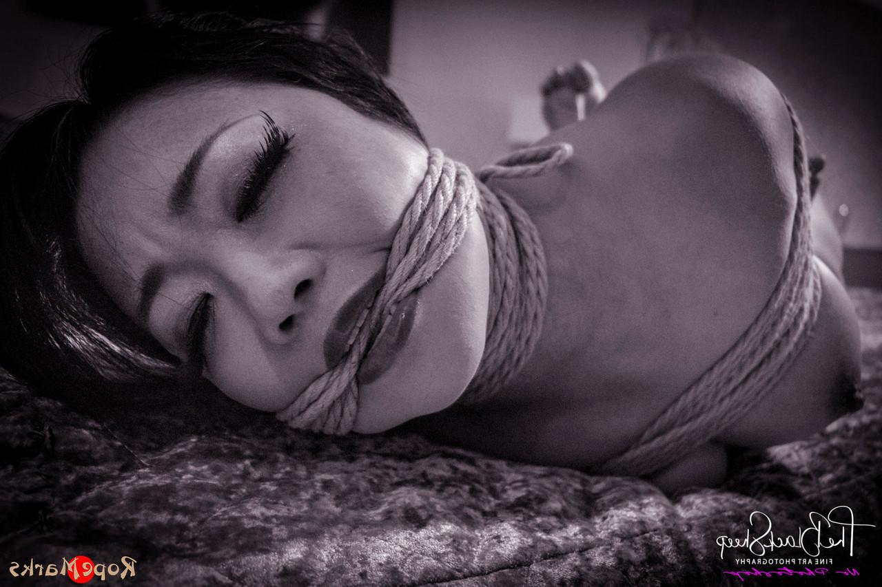 16P Asian chick is tied up with ropes on a bed before being blindfolded
