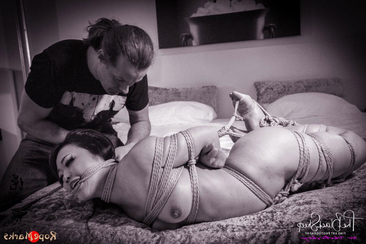 16P Asian chick is tied up with ropes on a bed before being blindfolded