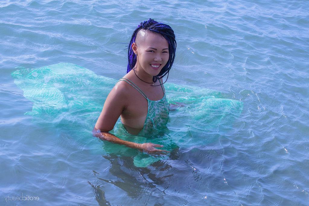 16P La jeune asiatique Sweet Julie émerge de l'océan pour se mettre nue.