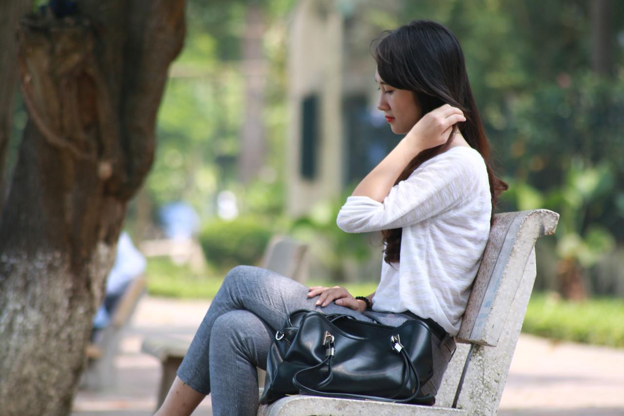 20P Menina asiática de tirar o fôlego posando de camisa branca e jeans em público