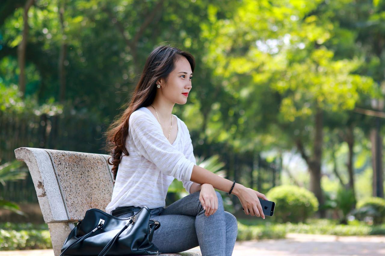 20P Menina asiática de tirar o fôlego posando de camisa branca e jeans em público
