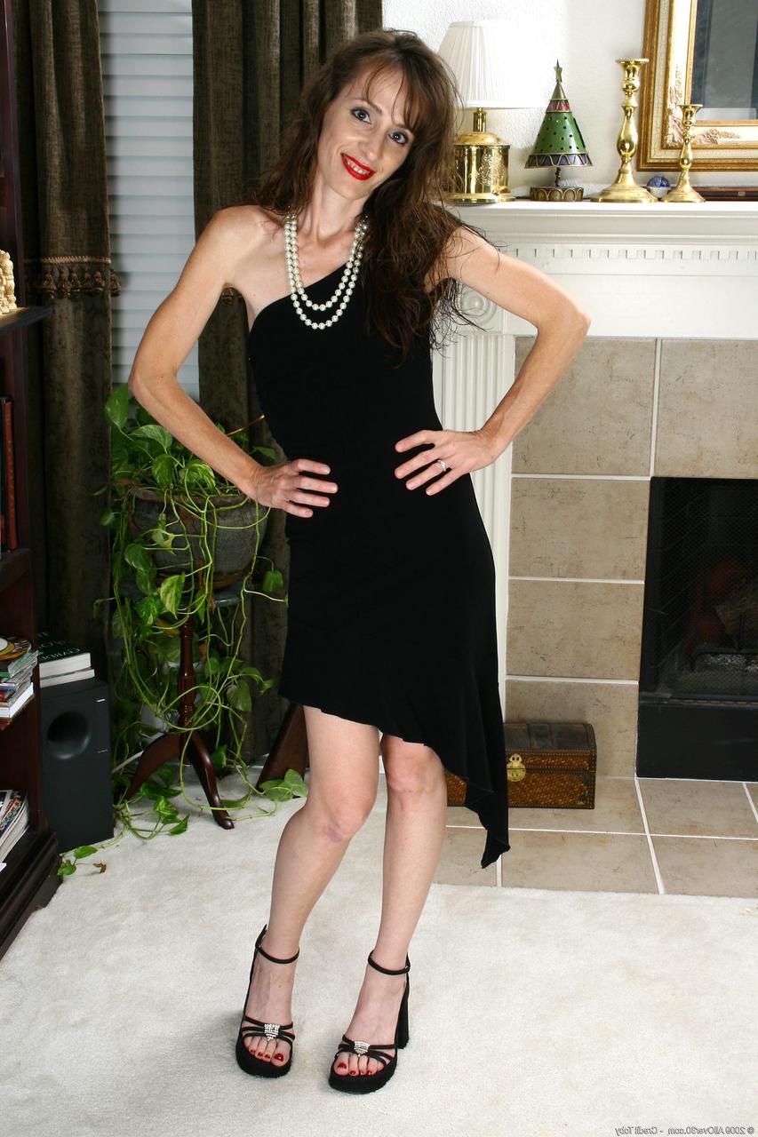 20P La chaude MILF Sydney S montre sa chatte poilue tout en l'excitant dans une robe noire sexy.