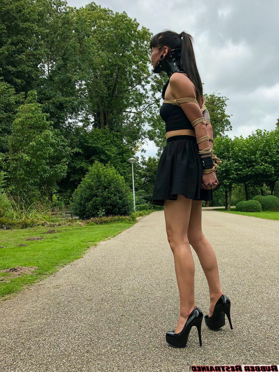 16P La asiática Flawless Meow lleva un collar con los brazos atados en un parque