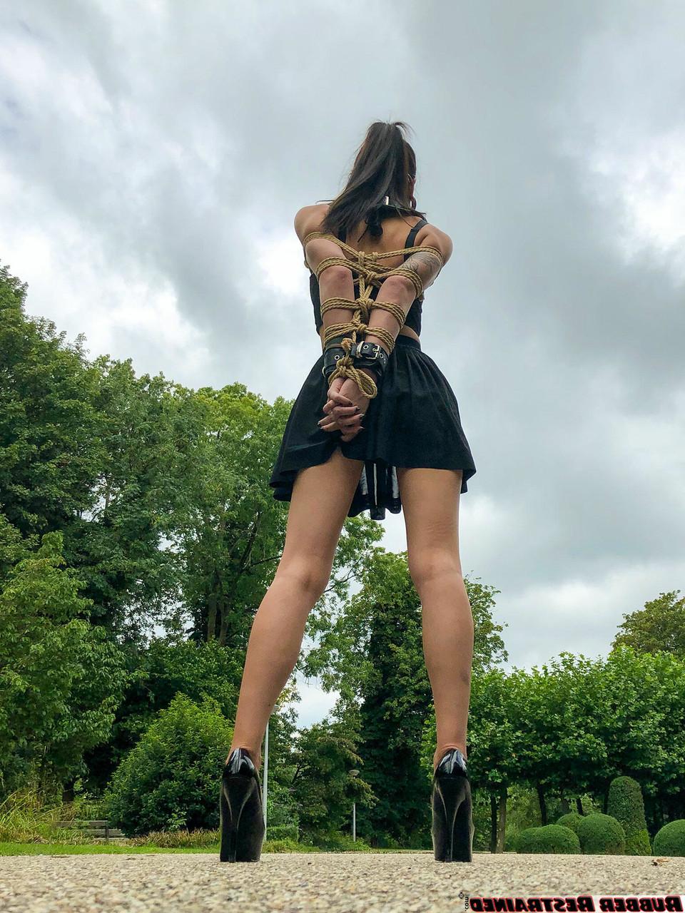 16P La asiática Flawless Meow lleva un collar con los brazos atados en un parque