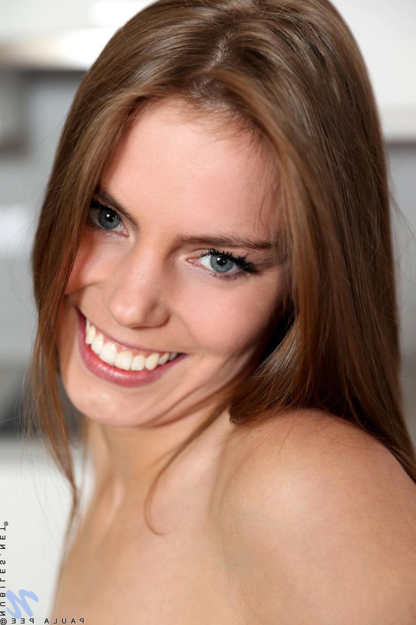 20P Die schlanke Teenagerin Paula Pee entblößt ihre Muschi und spielt damit auf dem Tisch