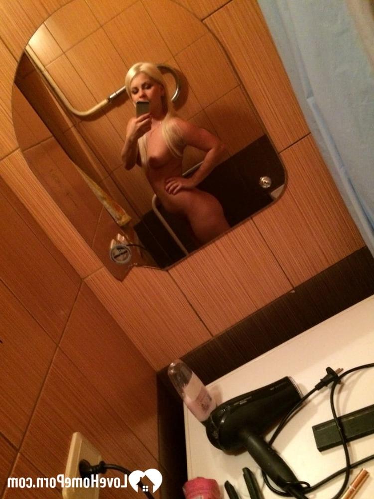 20P Une superbe blonde aux lèvres sexy prend des selfies de son corps chaud dans la salle de bain
