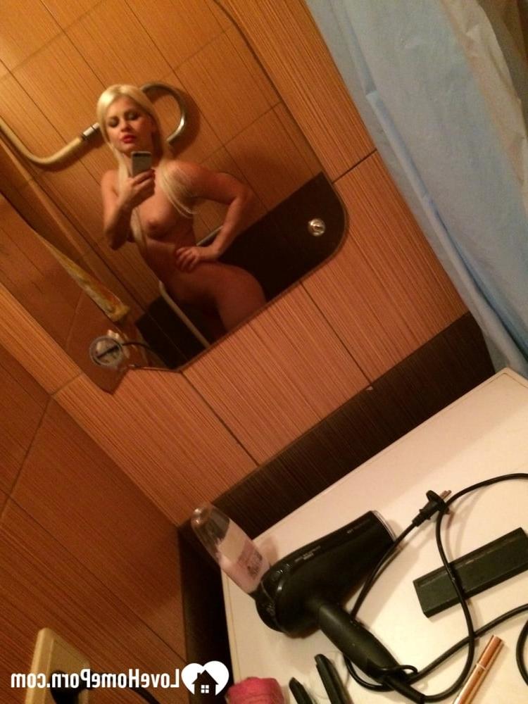20P Une superbe blonde aux lèvres sexy prend des selfies de son corps chaud dans la salle de bain