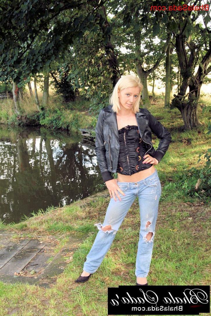15P A loirinha posa com seu espartilho, jaqueta de couro e jeans ao ar livre