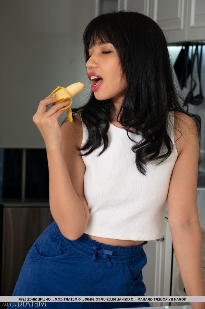 18P A linda adolescente asiática Norah come uma banana enquanto se despe