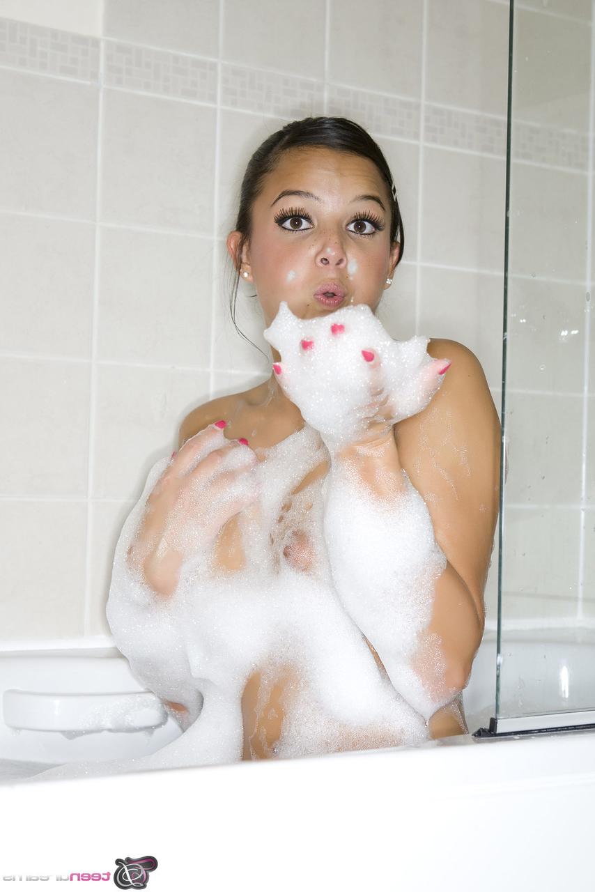 20P Sara, une jolie jeune amateur, se déshabille et montre son gros cul pendant un bain moussant.