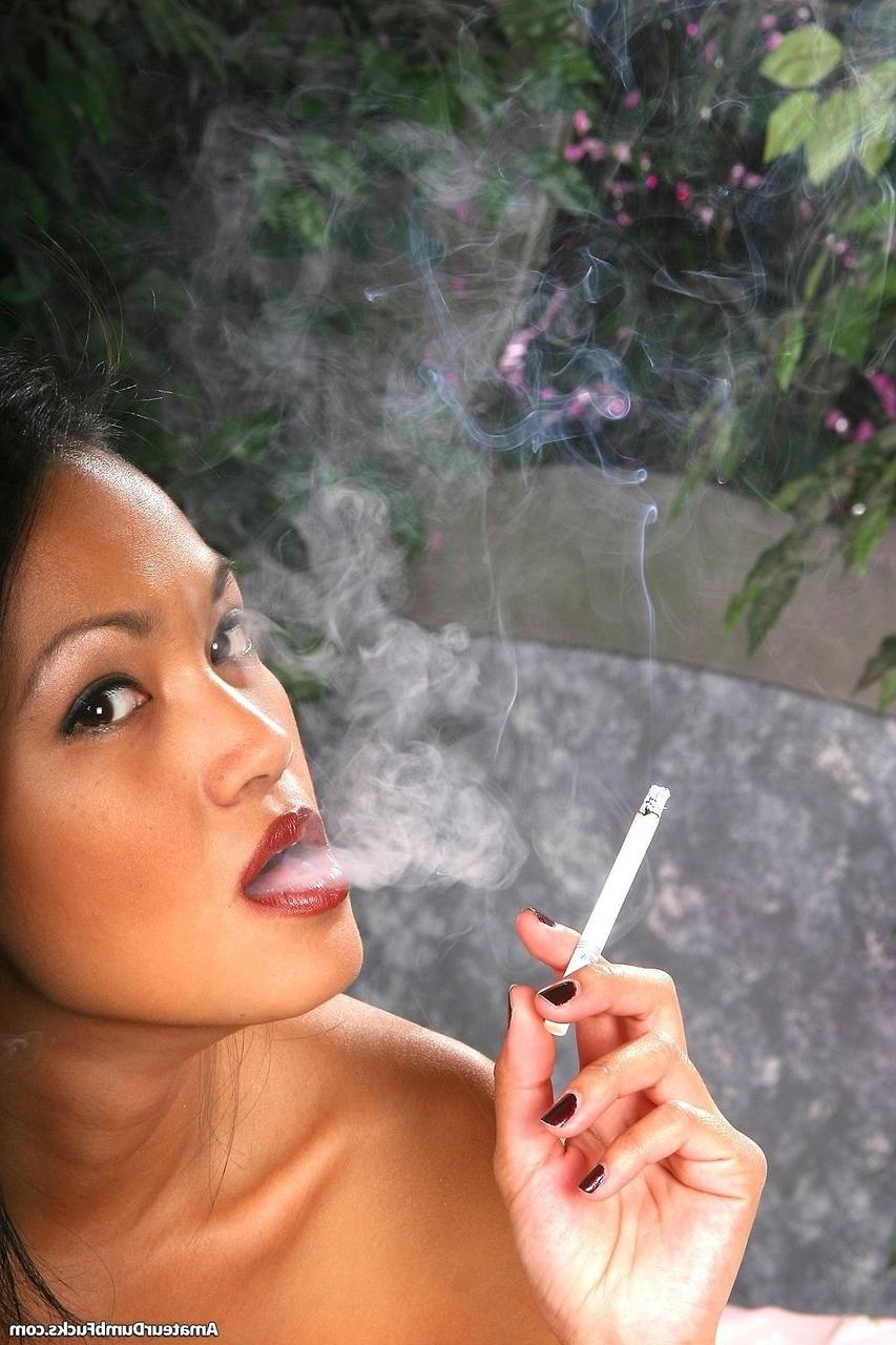 20P Beautiful Asian Iris Estrada smokes a cigarette while lying naked on her bed