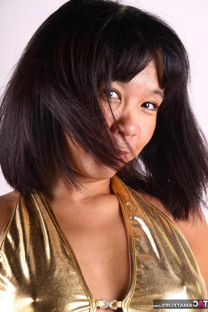 20P Asiática amateur juega con su cabello mientras modela un traje dorado