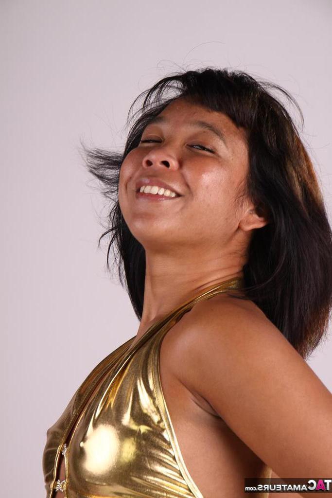 20P Asiática amateur juega con su cabello mientras modela un traje dorado