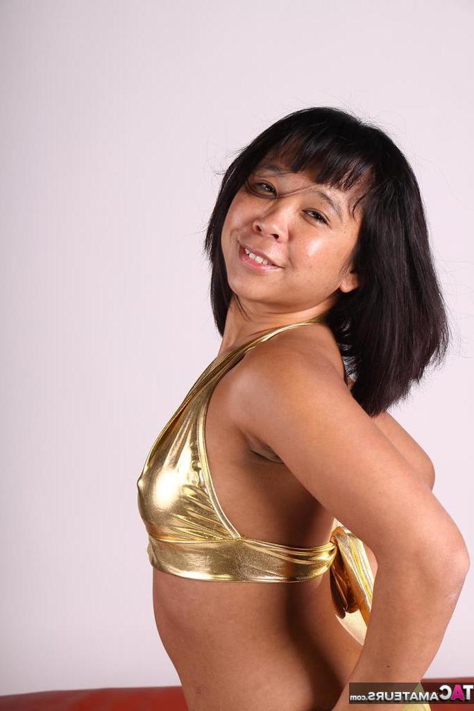 20P Asiática amateur juega con su cabello mientras modela un traje dorado