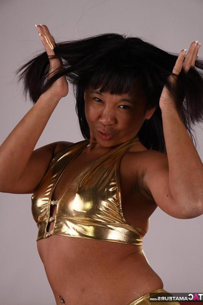 20P Asiática amateur juega con su cabello mientras modela un traje dorado
