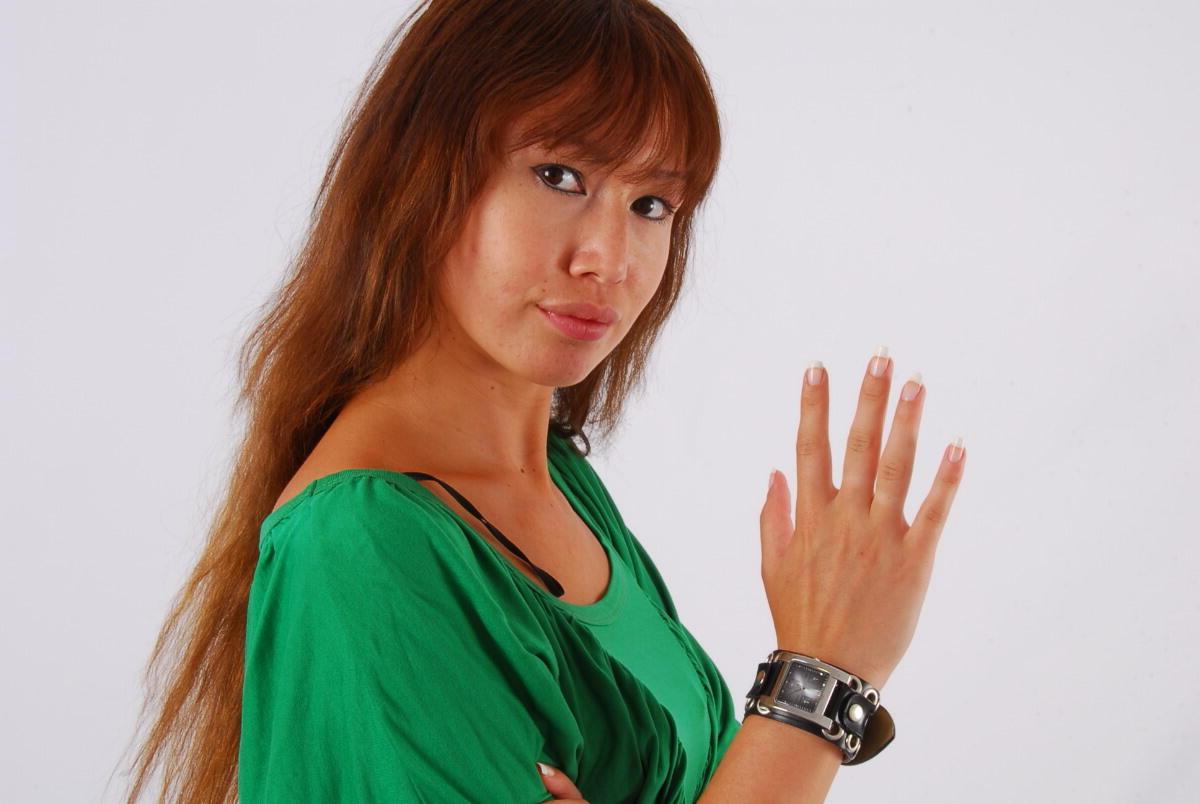 16P Redheaded Asian girl Evita models a Guess style cuff watch during SFW action
