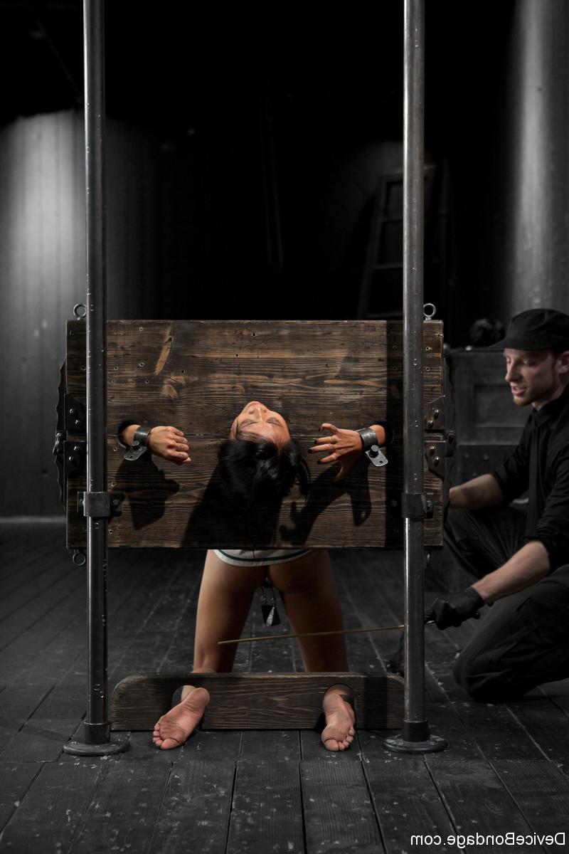 17P Pussy of Asian Krissie Dee caught in pillory is defenseless for man in black