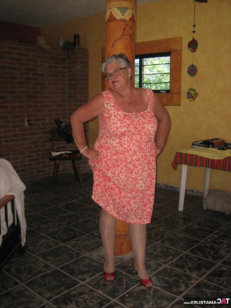 20P La abuela gorda Girdle Goddess sostiene sus tetas caídas en sus manos junto a un pilar