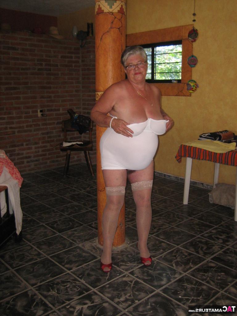 20P La abuela gorda Girdle Goddess sostiene sus tetas caídas en sus manos junto a un pilar