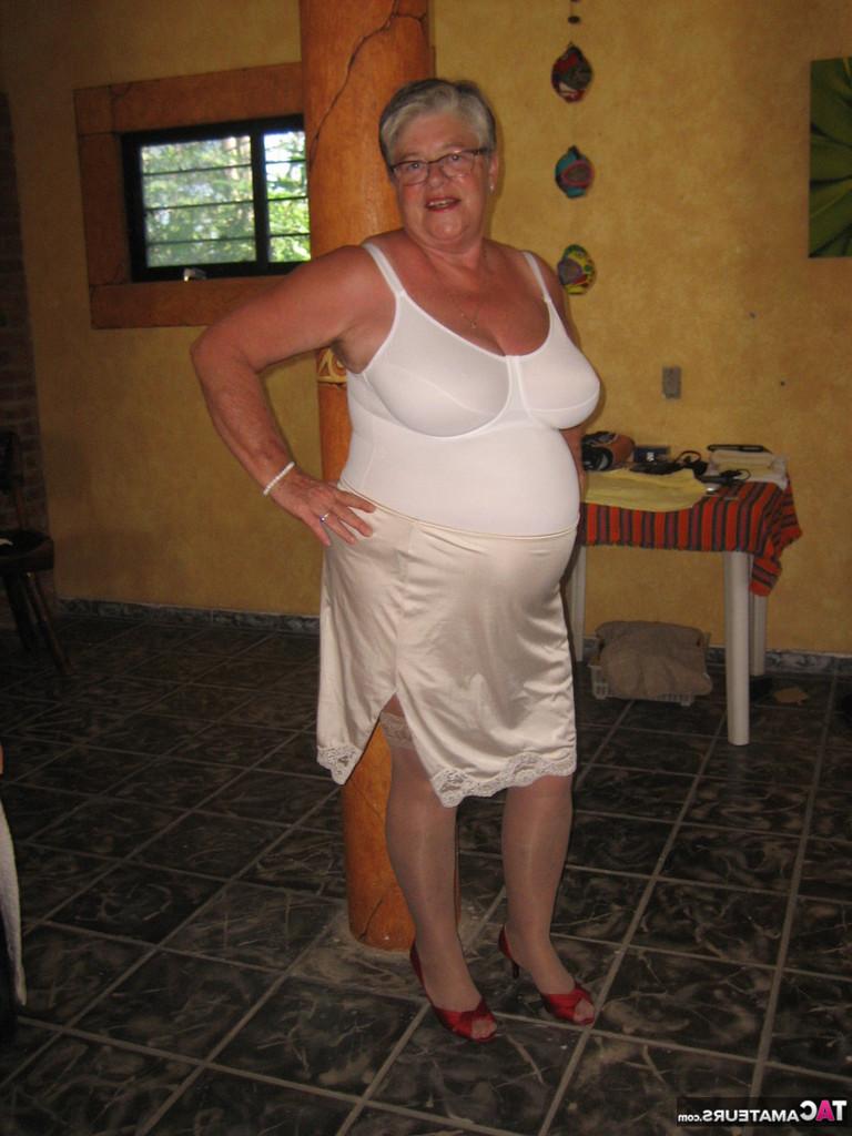 20P La abuela gorda Girdle Goddess sostiene sus tetas caídas en sus manos junto a un pilar