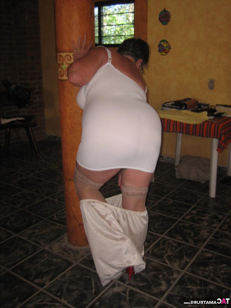 20P La abuela gorda Girdle Goddess sostiene sus tetas caídas en sus manos junto a un pilar