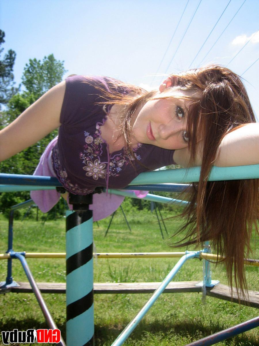 12P Une jeune rousse montre ses seins et sa culotte sur une aire de jeux