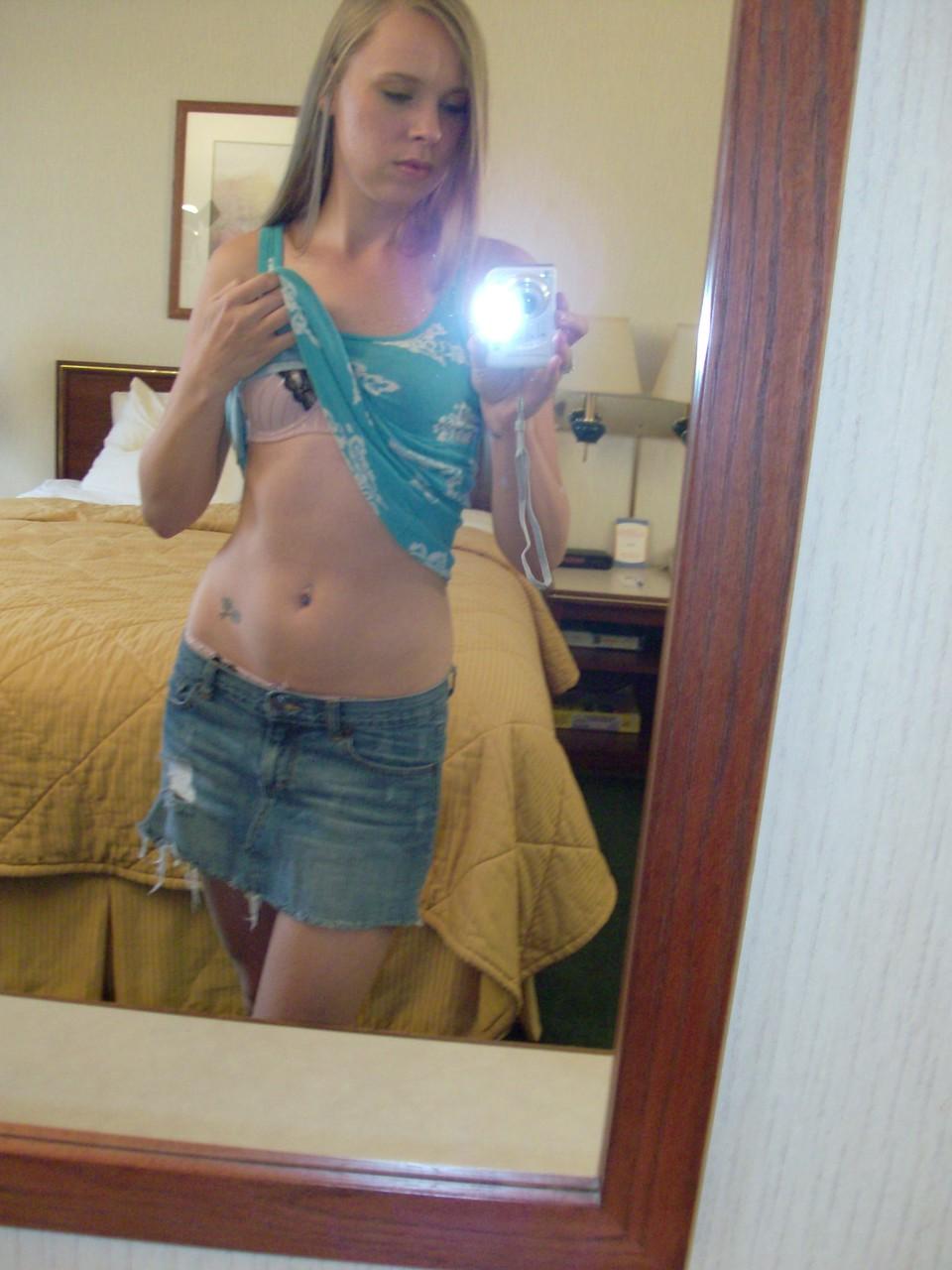 20P La chaude poupée amateur Ashley Ross prend des selfies pendant qu'elle se déshabille et pose devant le miroir.