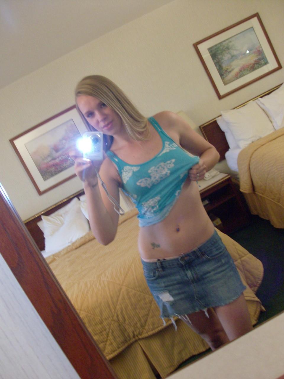 20P La chaude poupée amateur Ashley Ross prend des selfies pendant qu'elle se déshabille et pose devant le miroir.