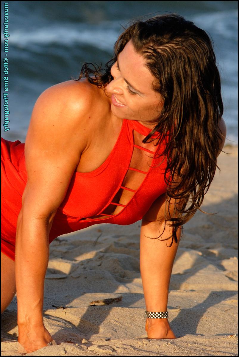 15P Die sexy brünette Bodybuilderin Lada Phihalova demonstriert in einem roten Kleid am Strand