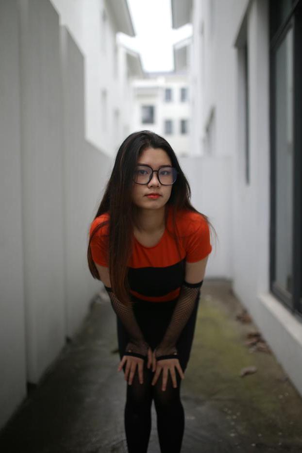 20P Garota asiática mal legal com óculos posando sedutoramente em público