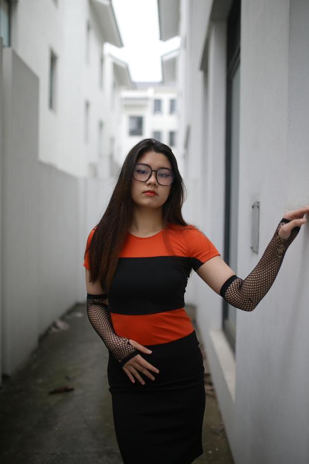 20P Garota asiática mal legal com óculos posando sedutoramente em público