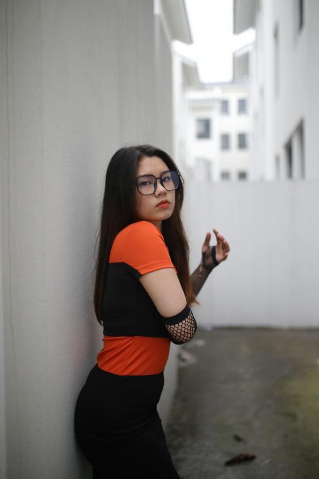 20P Garota asiática mal legal com óculos posando sedutoramente em público