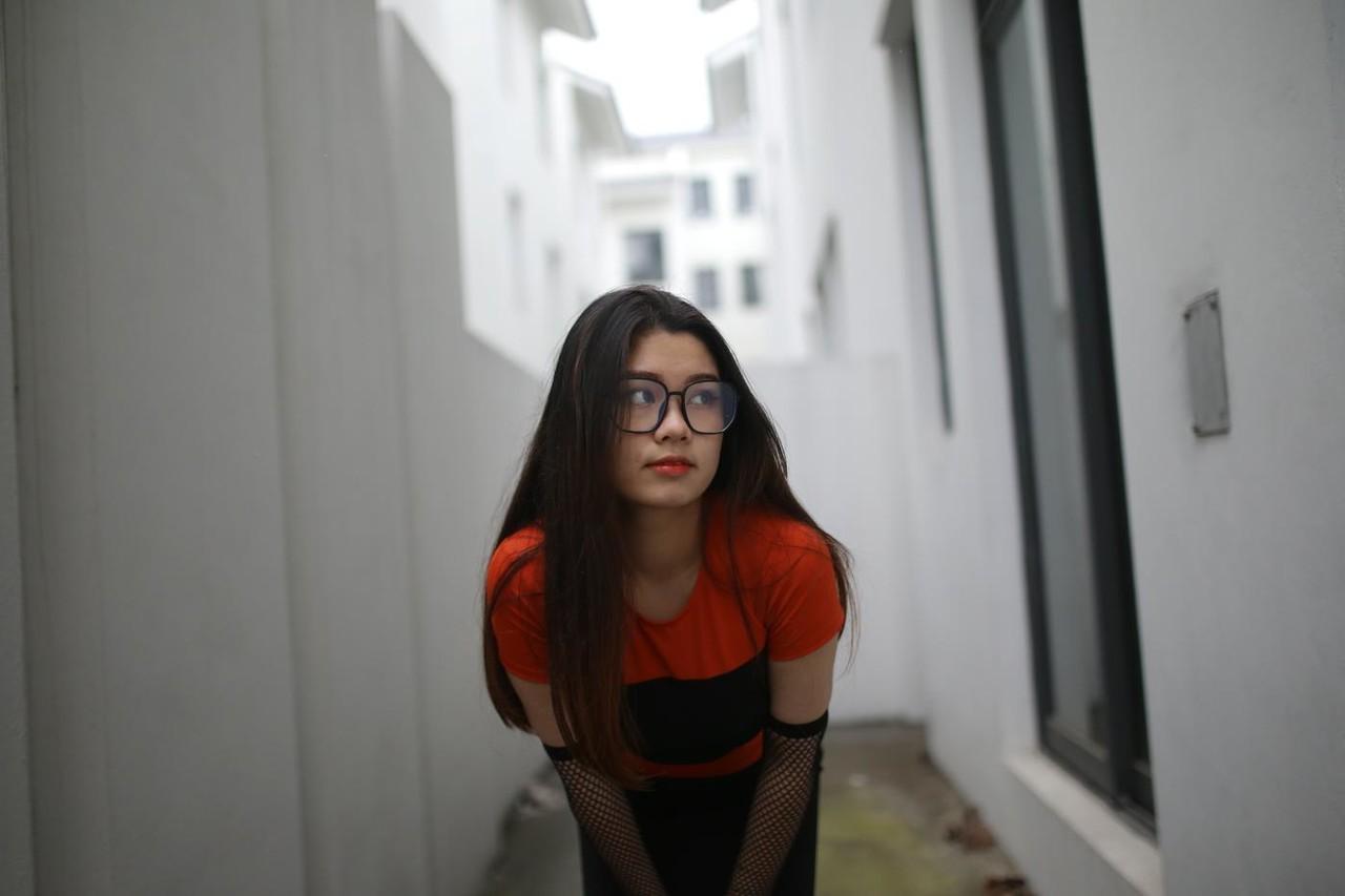 20P Garota asiática mal legal com óculos posando sedutoramente em público