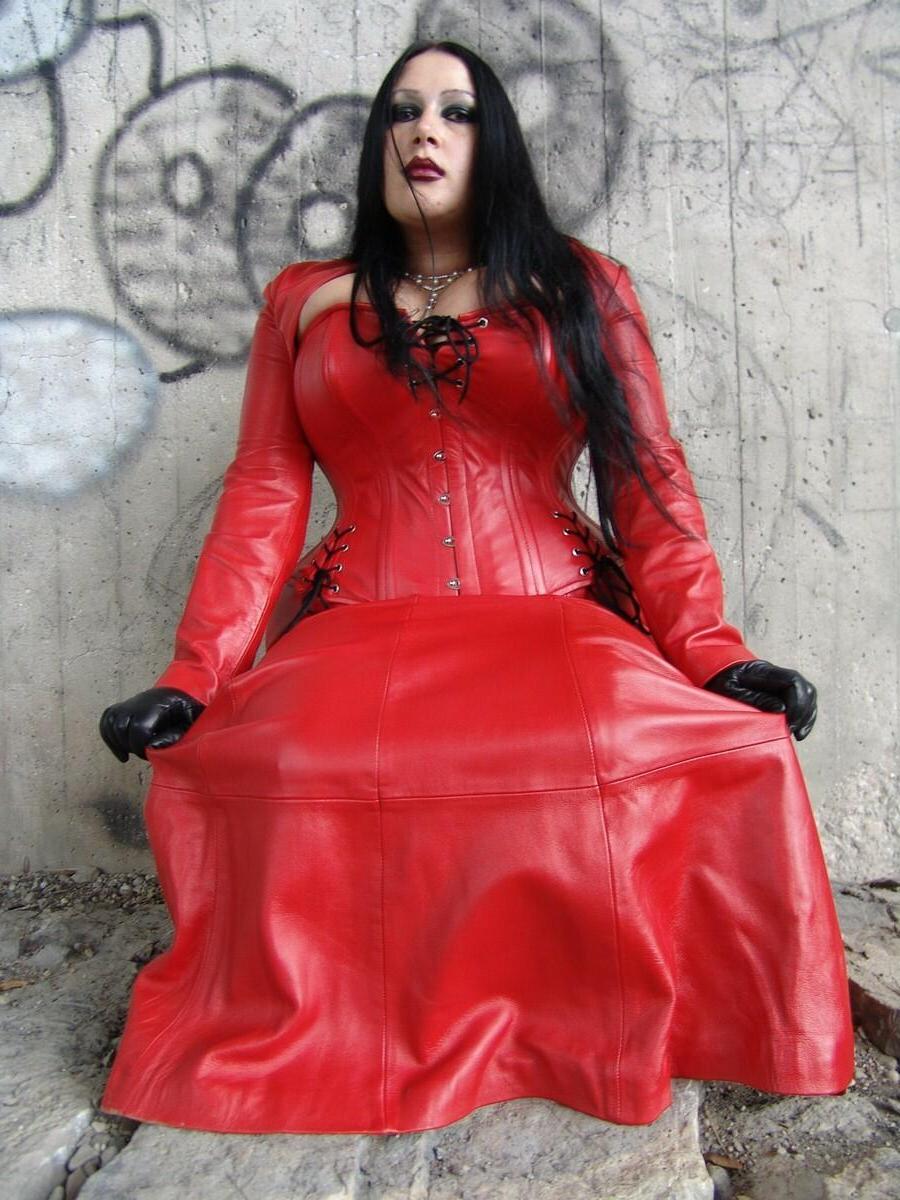 16P La mujer de cabello oscuro Lady Angelina libera sus grandes tetas de la ropa de látex roja